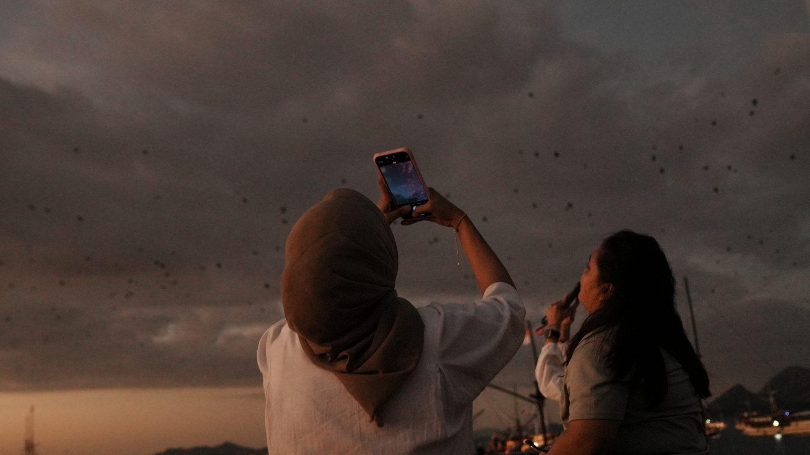 Kalong – Woman photographed as bats fly overhead (Foto reale da un viaggio KEXI)