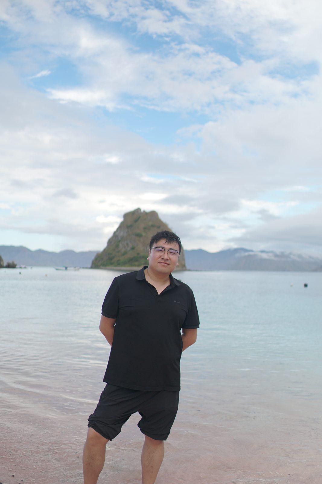 凯洛尔岛 – man standing in shallows, islet behind (KEXI 行程实拍)
