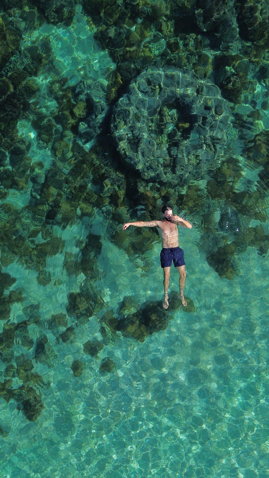 Swim Snorkel – man arms spread floating over dark reef (KEXI 行程实拍)
