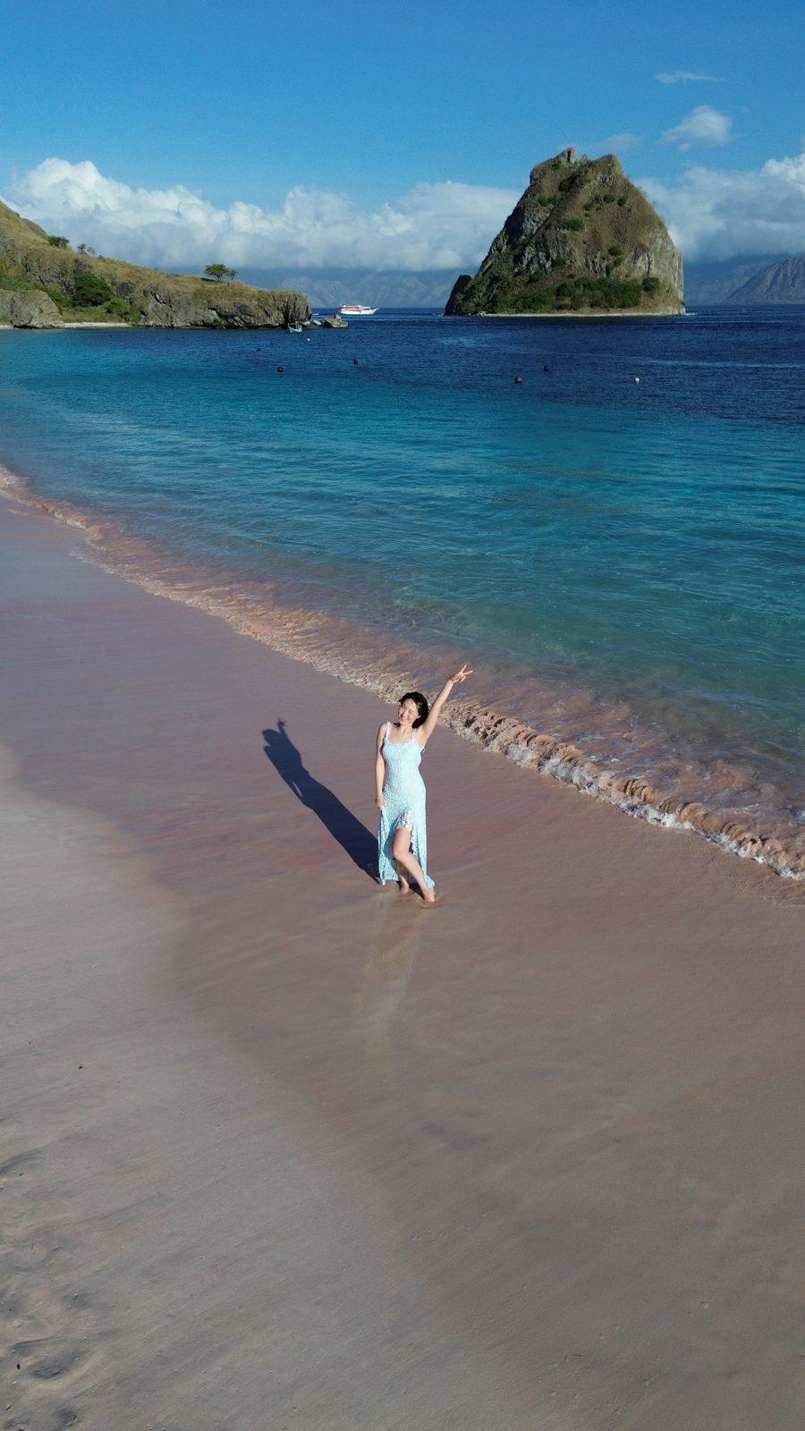 Swim Snorkel – woman in white at shore, rock islet behind (KEXI 行程实拍)