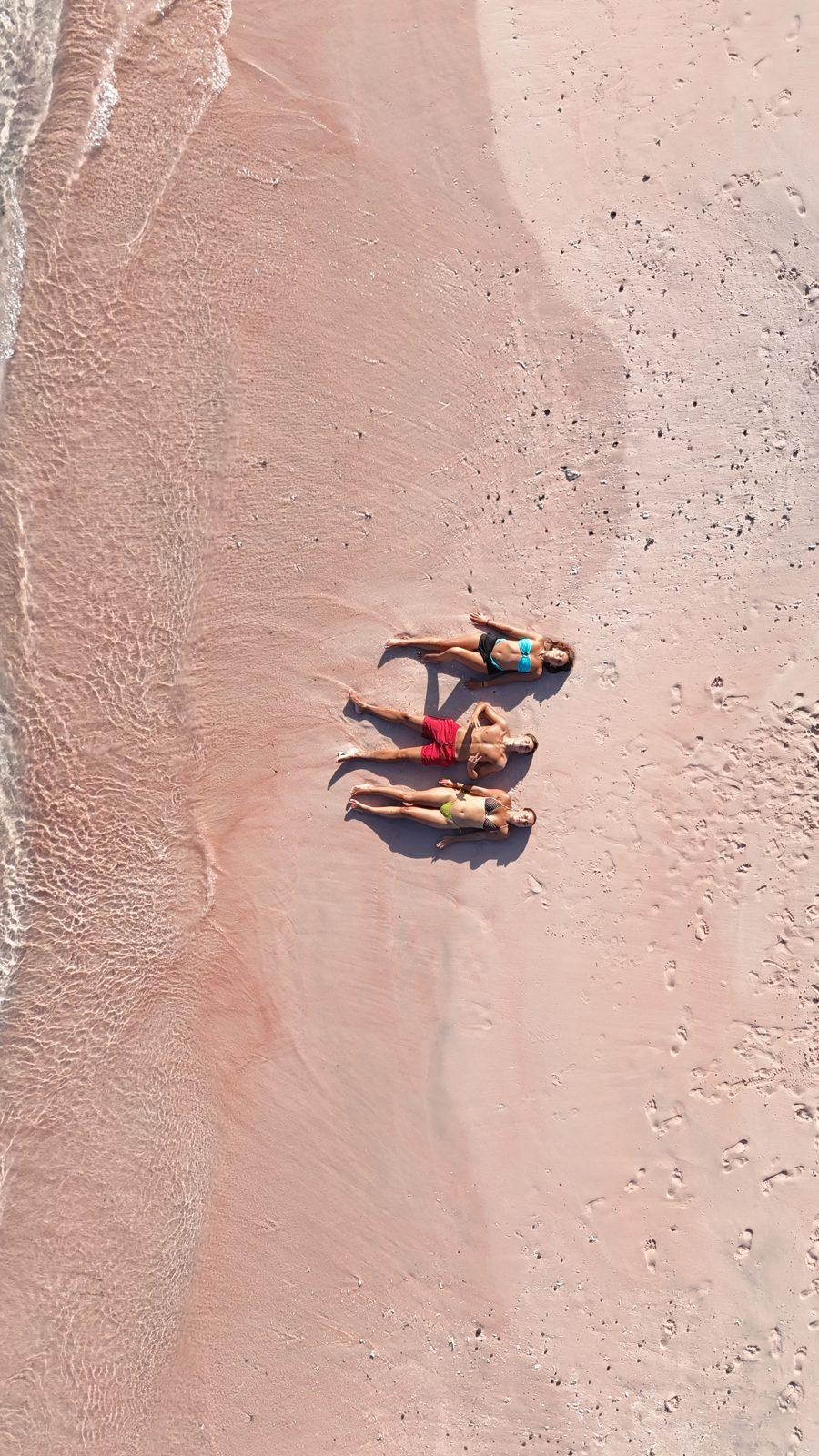 Pink Beach – two people lying on pink sand strip (Real photo from a KEXI trip)